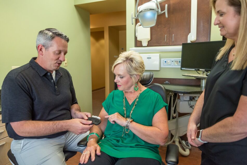 cosmetic dentist showing patient the different shades for teeth whitening in Little Rock, AR