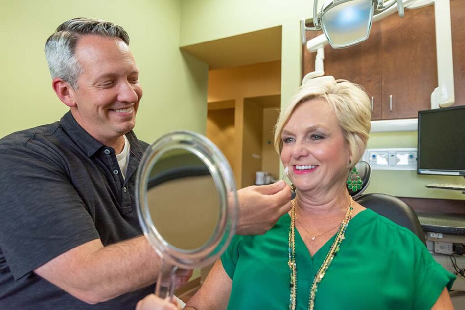 Dr. Reynolds, a skilled restorative dentist in showing a patient veneers in Little Rock, AR Cosmetic Dentistry Little Rock