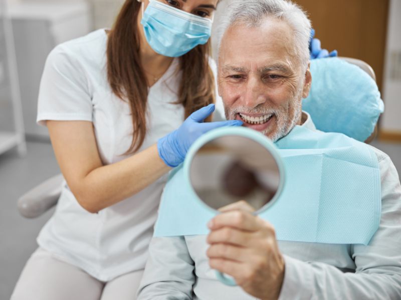 A patient admiring dental implants for seniors in Little Rock